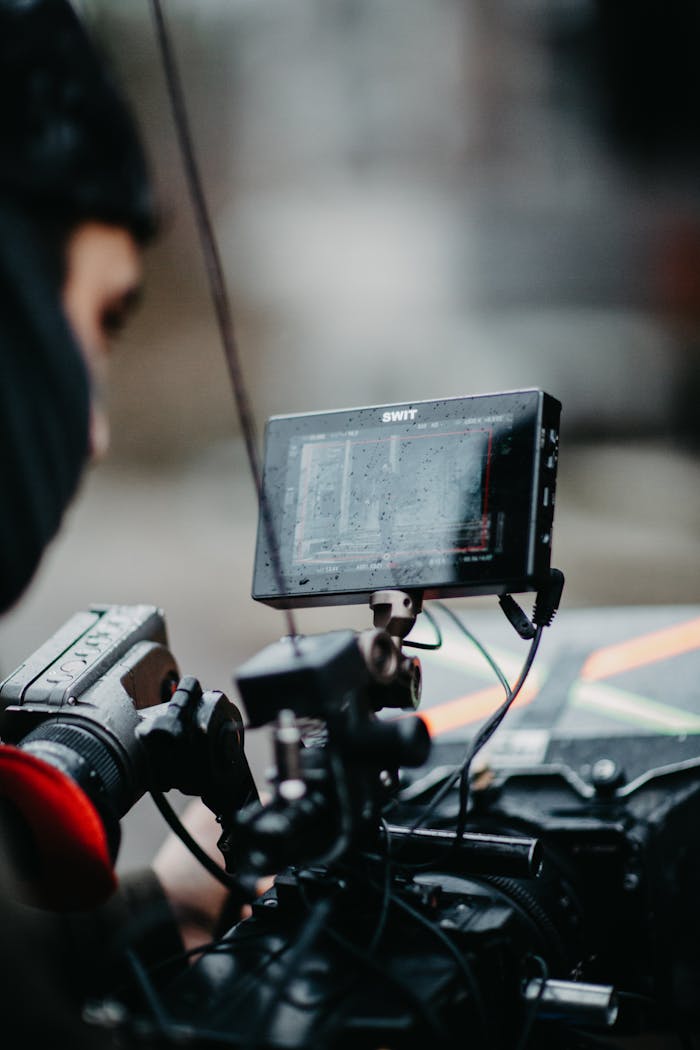A professional cameraman operates advanced filming equipment in an indoor setting.
